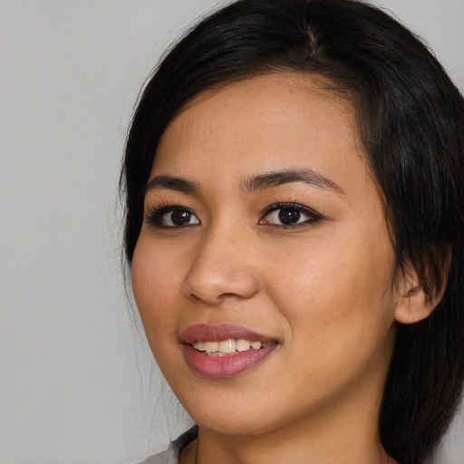 Joyful asian young-adult female with long  black hair and brown eyes