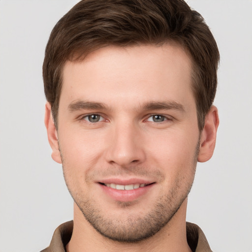 Joyful white young-adult male with short  brown hair and grey eyes