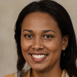 Joyful black adult female with long  brown hair and brown eyes