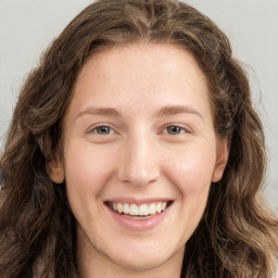 Joyful white young-adult female with long  brown hair and green eyes