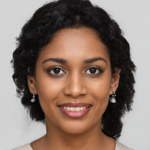 Joyful black young-adult female with long  black hair and brown eyes