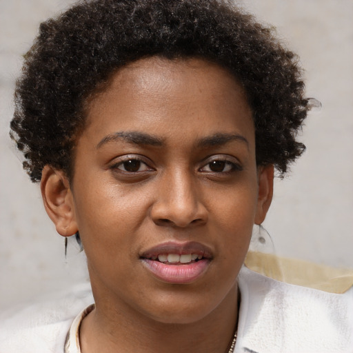 Joyful black young-adult female with short  brown hair and brown eyes