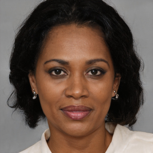 Joyful latino adult female with medium  brown hair and brown eyes