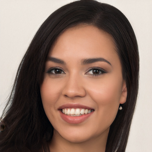 Joyful latino young-adult female with long  brown hair and brown eyes