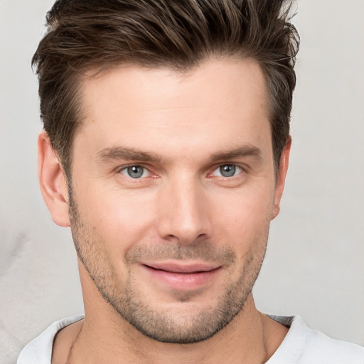 Joyful white young-adult male with short  brown hair and grey eyes