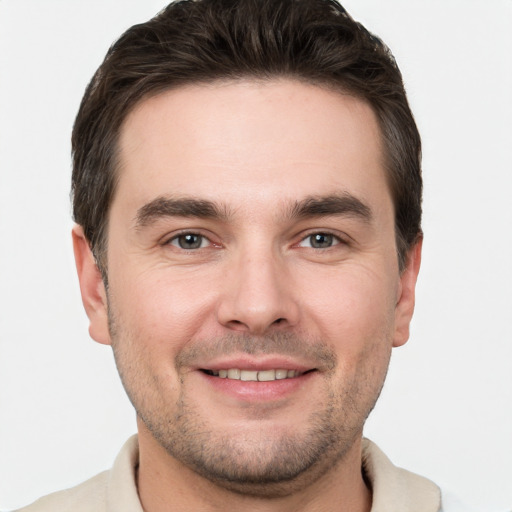 Joyful white young-adult male with short  brown hair and grey eyes