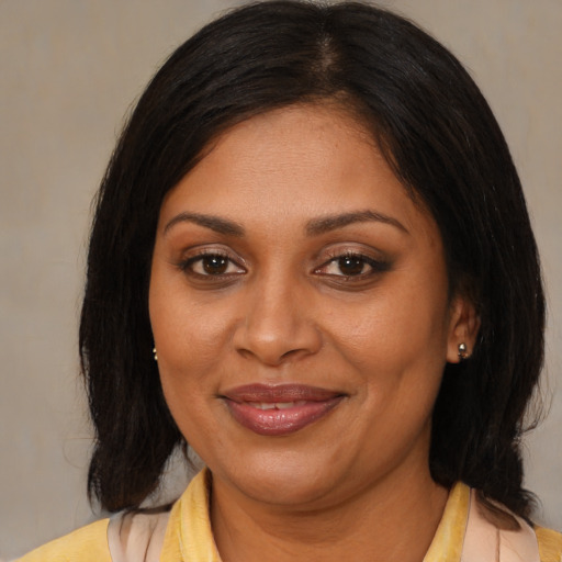 Joyful black adult female with medium  brown hair and brown eyes