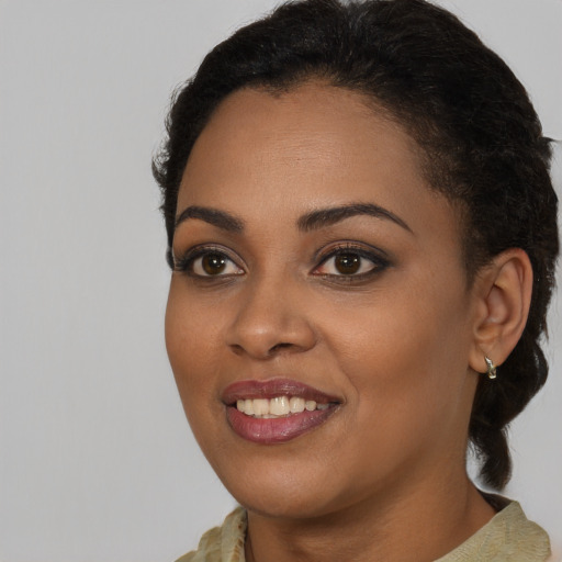 Joyful black young-adult female with medium  brown hair and brown eyes