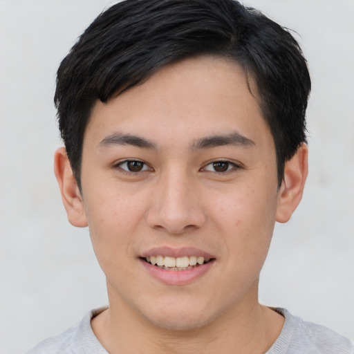 Joyful asian young-adult male with short  brown hair and brown eyes