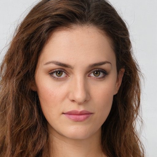 Joyful white young-adult female with long  brown hair and green eyes