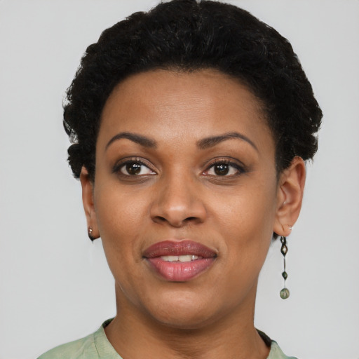 Joyful black young-adult female with short  black hair and brown eyes