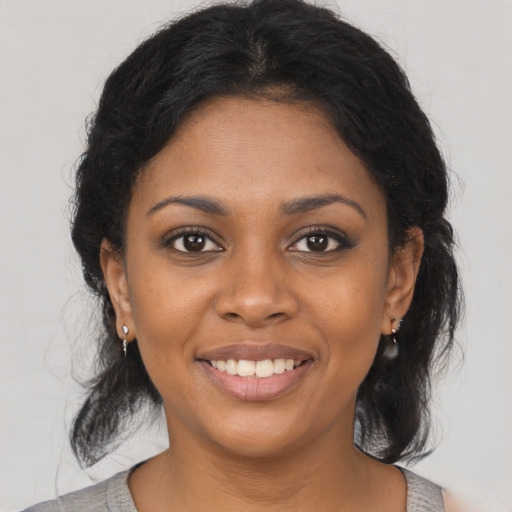 Joyful black young-adult female with medium  black hair and brown eyes