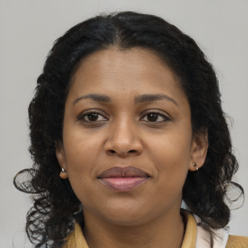 Joyful black young-adult female with long  brown hair and brown eyes