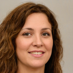 Joyful white young-adult female with long  brown hair and green eyes