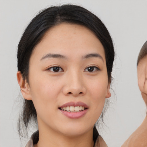 Joyful asian young-adult female with medium  brown hair and brown eyes