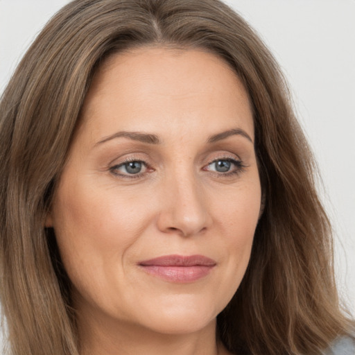 Joyful white adult female with long  brown hair and brown eyes