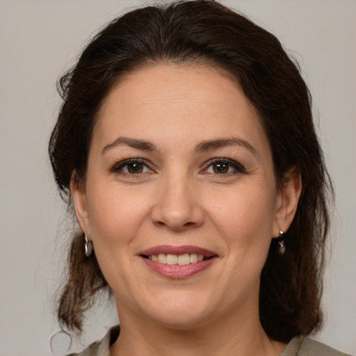 Joyful white adult female with medium  brown hair and brown eyes