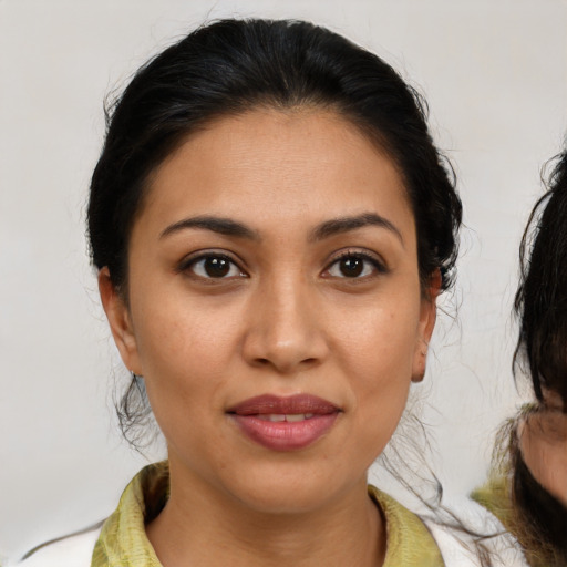 Joyful latino young-adult female with medium  brown hair and brown eyes