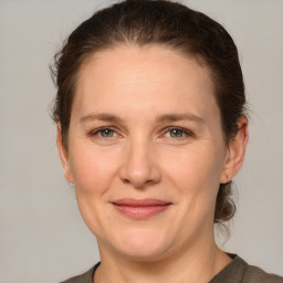 Joyful white adult female with medium  brown hair and grey eyes