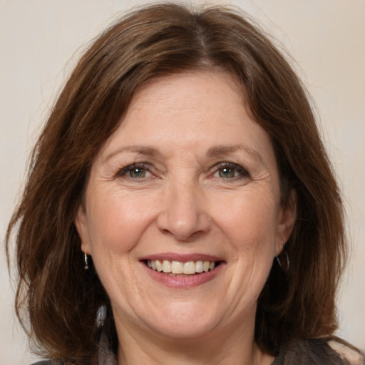 Joyful white adult female with medium  brown hair and grey eyes