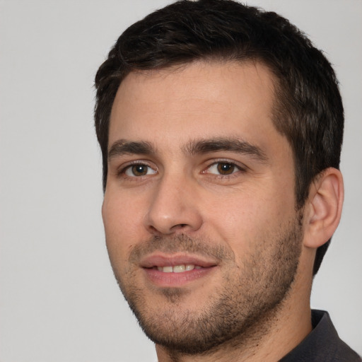 Joyful white young-adult male with short  black hair and brown eyes