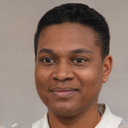 Joyful black young-adult male with short  black hair and brown eyes