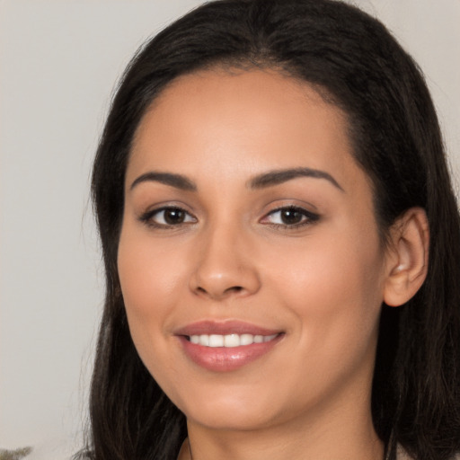 Joyful latino young-adult female with long  brown hair and brown eyes