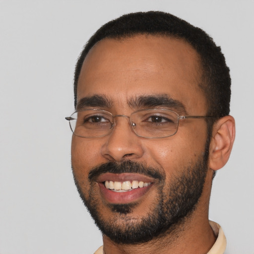 Joyful black young-adult male with short  black hair and brown eyes