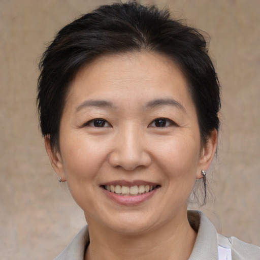 Joyful asian adult female with medium  brown hair and brown eyes