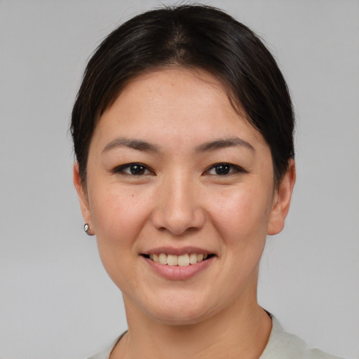 Joyful asian young-adult female with short  brown hair and brown eyes