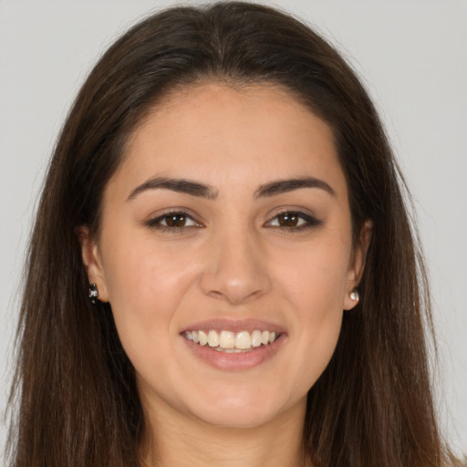 Joyful white young-adult female with long  brown hair and brown eyes