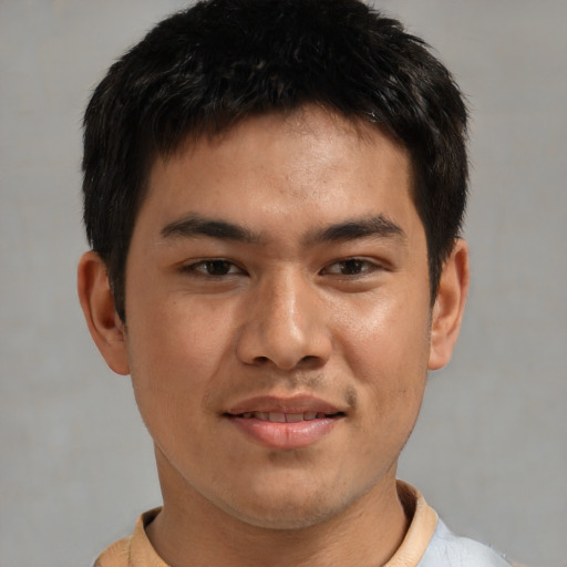 Joyful asian young-adult male with short  brown hair and brown eyes