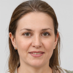 Joyful white adult female with medium  brown hair and grey eyes