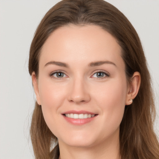 Joyful white young-adult female with long  brown hair and grey eyes