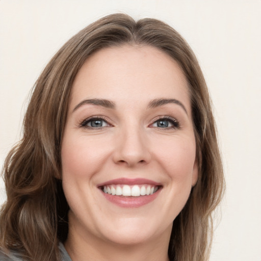 Joyful white young-adult female with medium  brown hair and green eyes