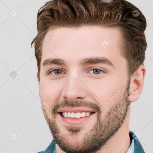 Joyful white young-adult male with short  brown hair and grey eyes