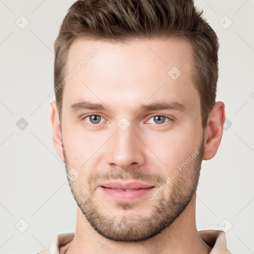 Joyful white young-adult male with short  brown hair and grey eyes