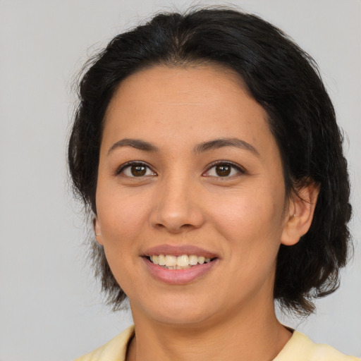 Joyful latino young-adult female with medium  brown hair and brown eyes