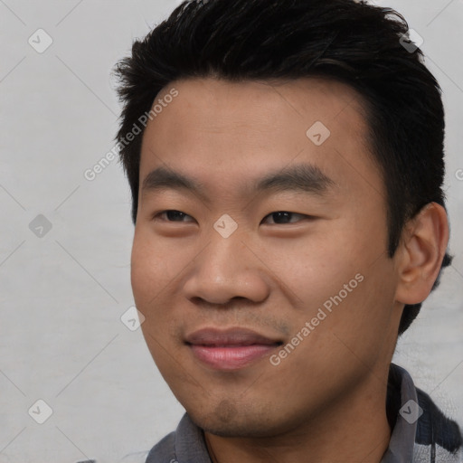 Joyful asian young-adult male with short  black hair and brown eyes