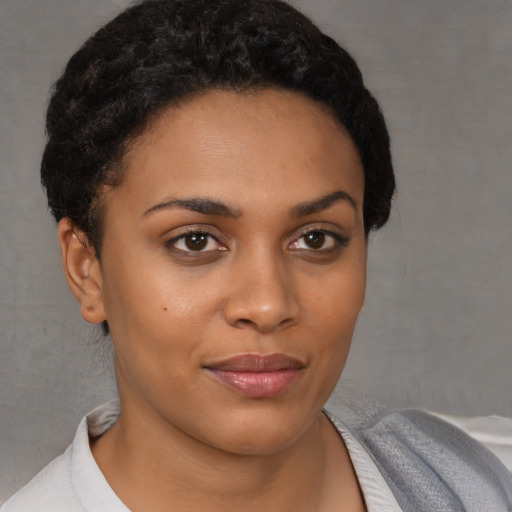 Joyful black young-adult female with short  brown hair and brown eyes