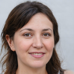 Joyful white adult female with long  brown hair and brown eyes