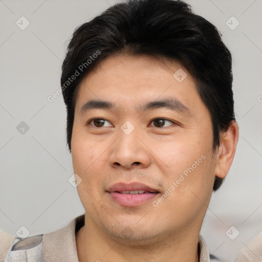 Joyful asian young-adult male with short  black hair and brown eyes