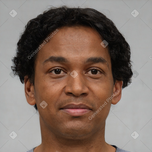 Joyful black young-adult male with short  brown hair and brown eyes