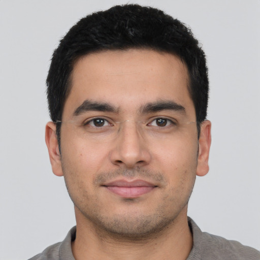 Joyful latino young-adult male with short  black hair and brown eyes