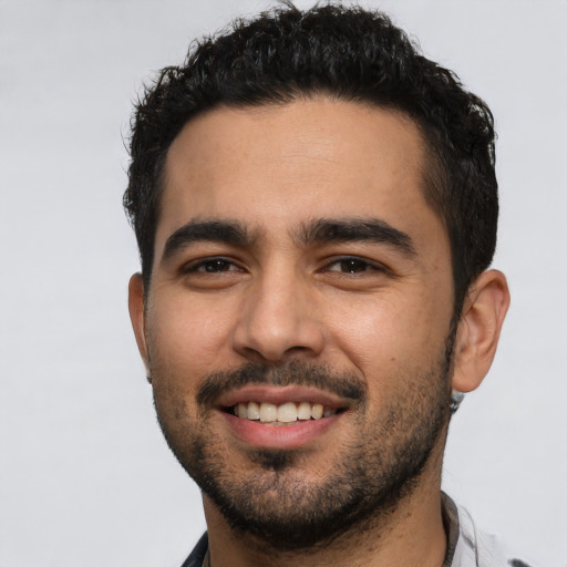 Joyful latino young-adult male with short  black hair and brown eyes