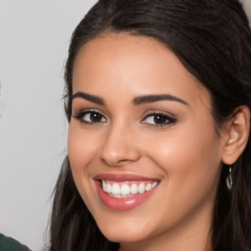 Joyful latino young-adult female with long  brown hair and brown eyes