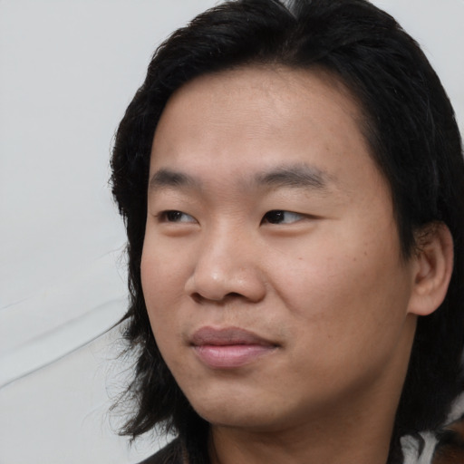 Joyful asian young-adult male with medium  black hair and brown eyes