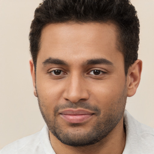 Joyful black young-adult male with short  brown hair and brown eyes