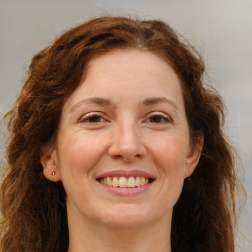 Joyful white adult female with long  brown hair and green eyes