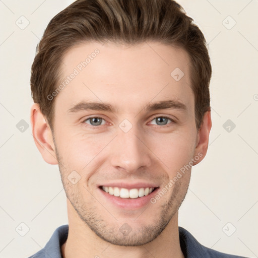 Joyful white young-adult male with short  brown hair and grey eyes